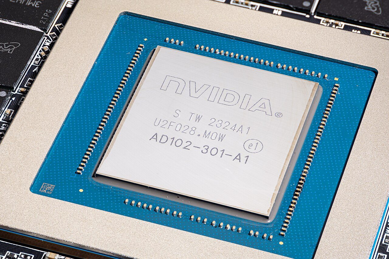 Close-up of the AD102 chip on an RTX 4090 board: a silver square laser-marked NVIDIA AD102-301-A1, on a blue package substrate inside a metal frame