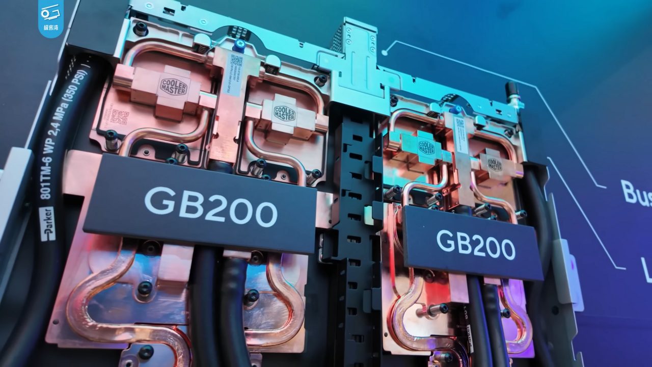 Two GB200 boards fitted with copper cold plates and black coolant hoses, on display at a trade show