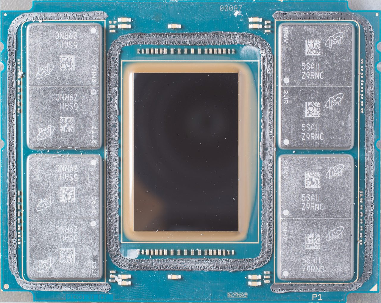 An Intel Knights Landing package from above: a large dark rectangular die in the centre, surrounded on left and right by eight silver memory packages in two columns of four, on a turquoise substrate