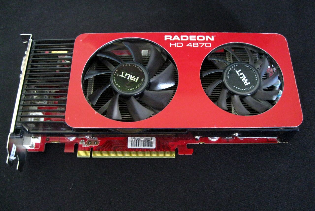 A Palit Radeon HD 4870 graphics card with a red cooler and two black fans, photographed on a dark background