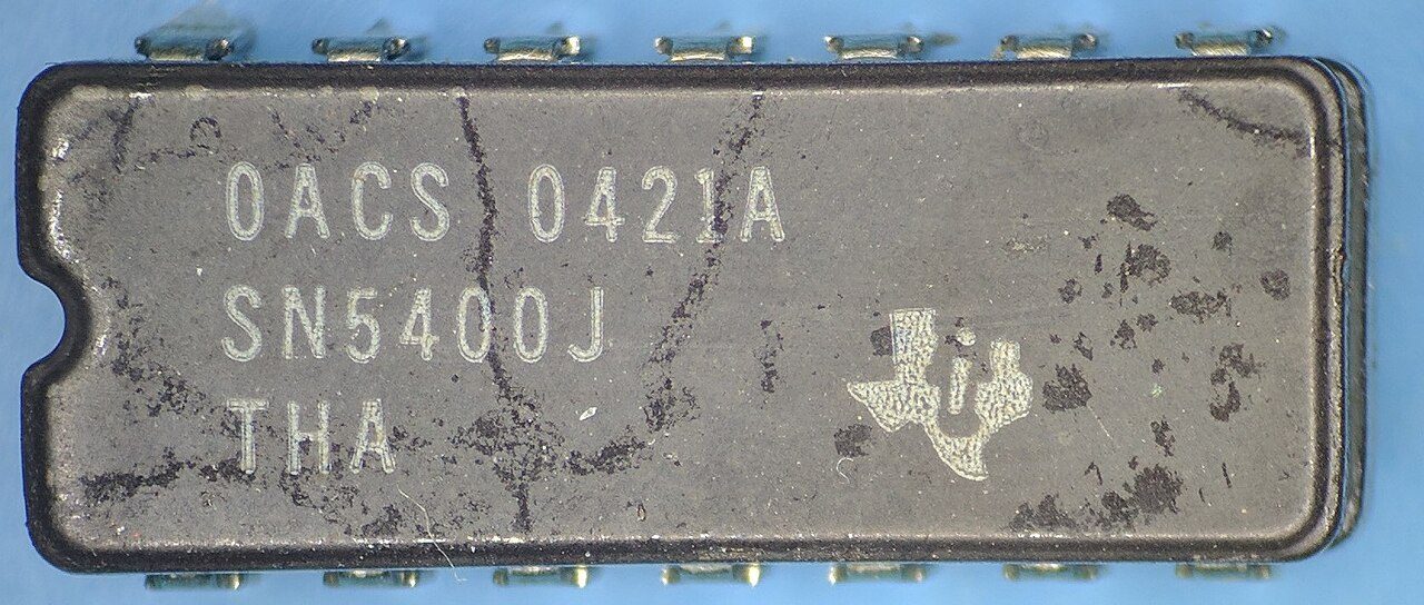 A Texas Instruments SN5400J chip: a grey ceramic package with fourteen leads, marked with the TI logo