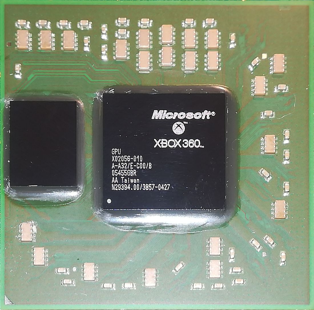 The Xbox 360's graphics package on a green circuit board: a large square chip marked Microsoft XBOX 360 and GPU, and beside it a smaller plain dark square die